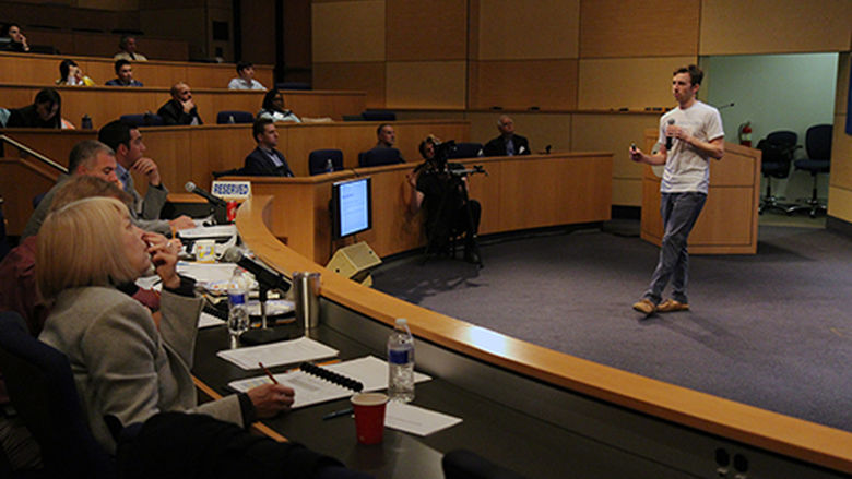 Student presenting business ideas in an auditorium to a panel of judges