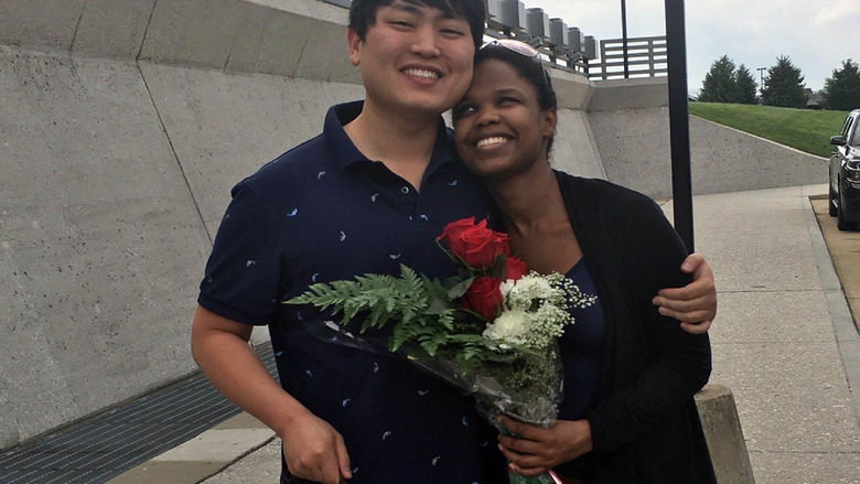 Andy Park hugs his wife, who is holding flowers