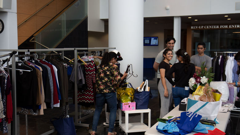 Students looking at clothes and household items in the CCB lobby