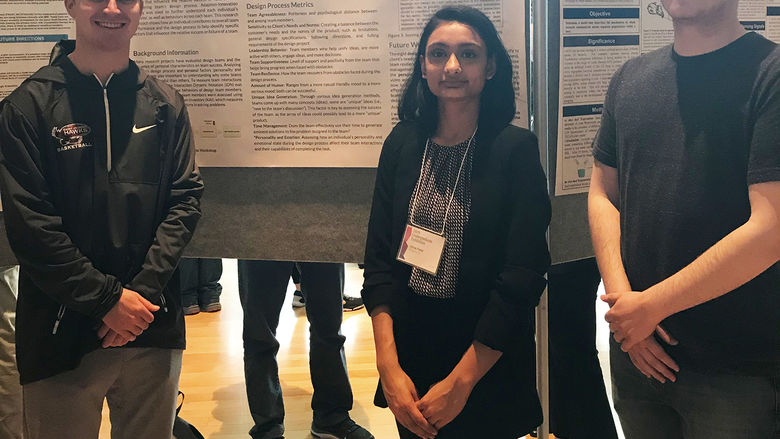 Students in front of poster at research symposium