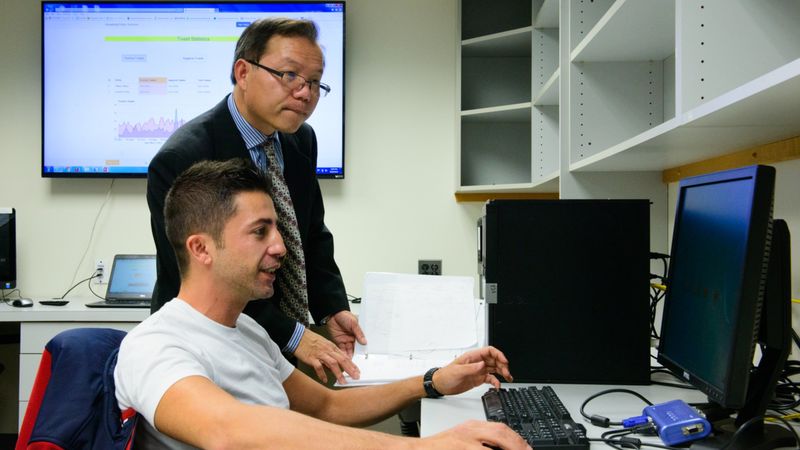 Teacher and student looking at computer