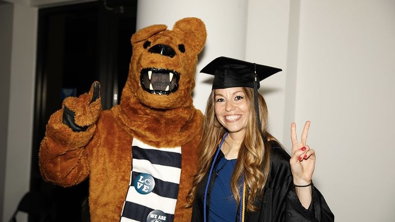 NEW GRADUATE AND LION GIVE PEACE SIGNS 
