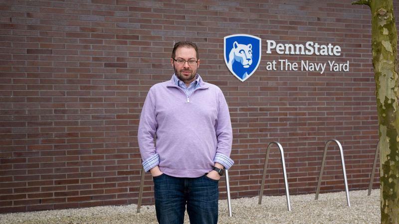 Todd Krout standing in front of the Penn State at the Navy Yard logo on Build 7R at the Navy Yard