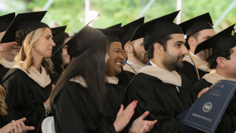 students clap at graduation