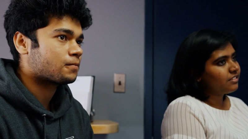 Nimisha Benoy and Utkarsh Singh sit in a classroom