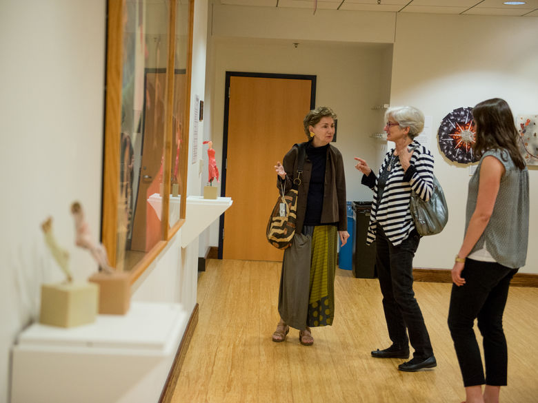 Photo of three women looking at artwork in Henry Gallery