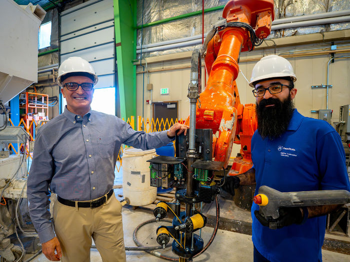 two people standing in machine shop