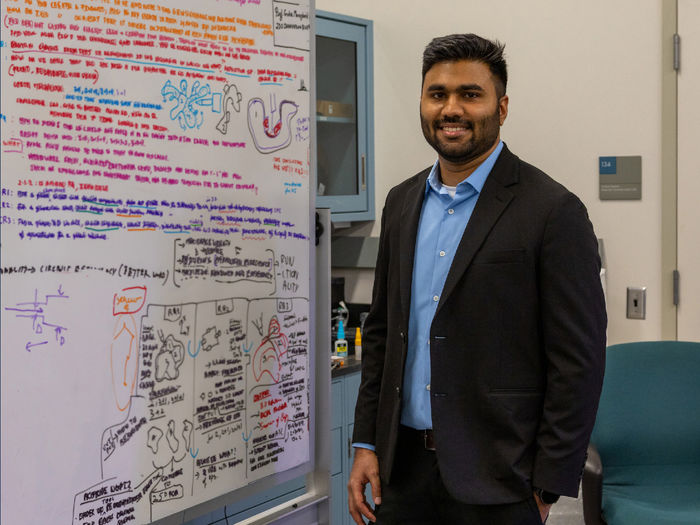 person standing in front of white board with equations