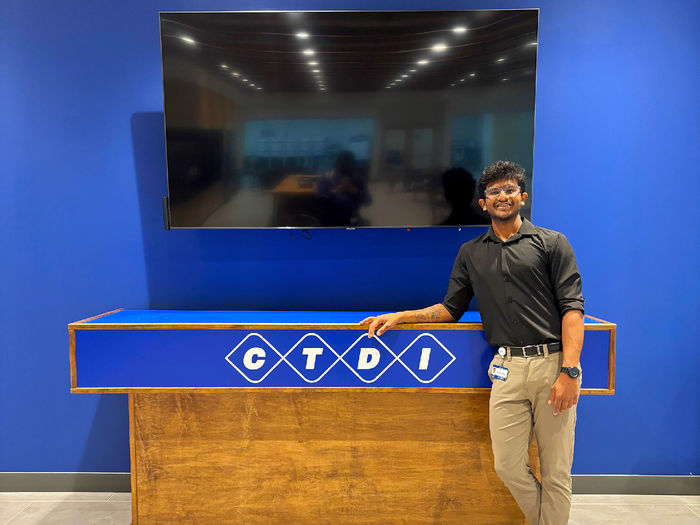 student standing next to TV and CTDI company sign