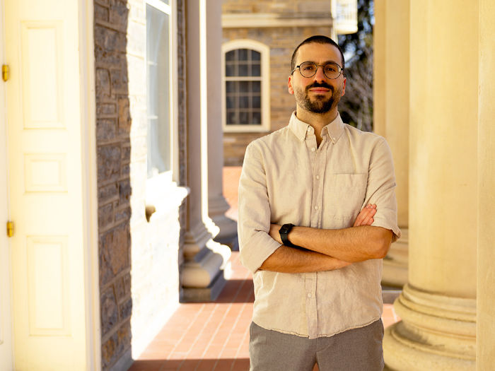person standing next to Old Main pillars