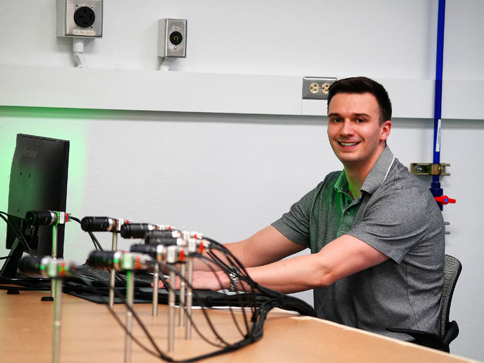 man sitting at computer posing for photo