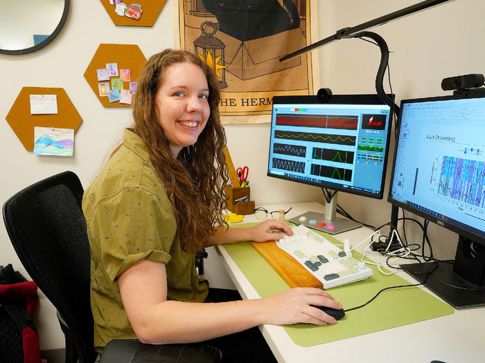 woman sitting at computer smiling at camera