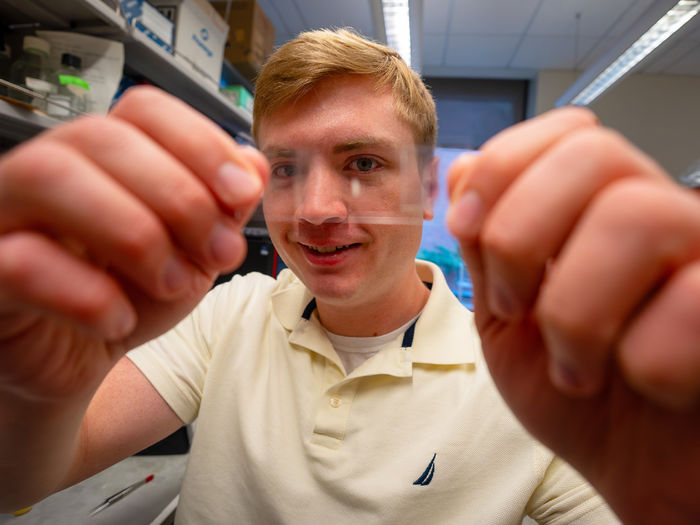 man holding thin film in front of his face