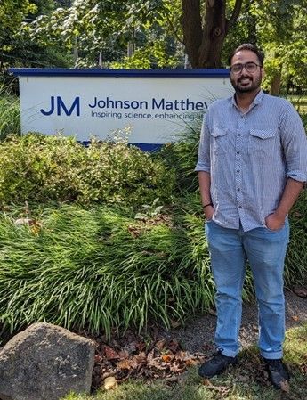 Parth Trivedi standing next to the Johnson Matthey sign