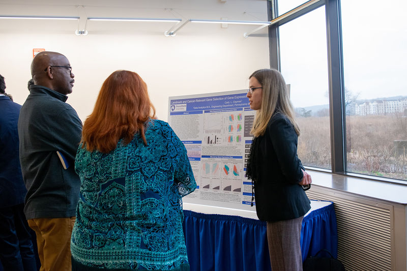 A student explaining her research to judges