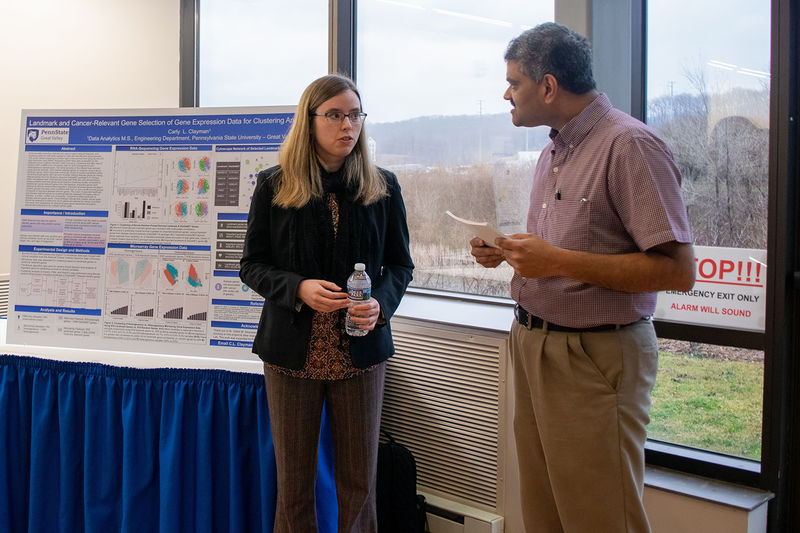 A student discusses her research with a judge