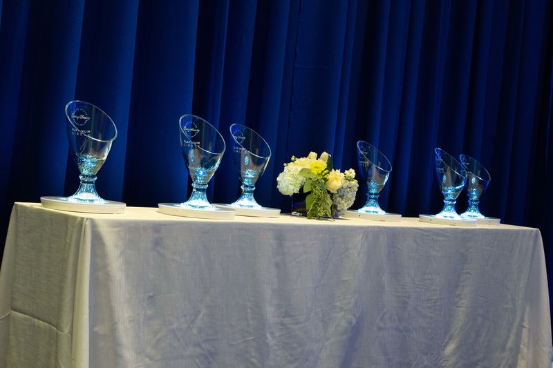Glass vases etched with the Great Valley Giving Society logo on a table