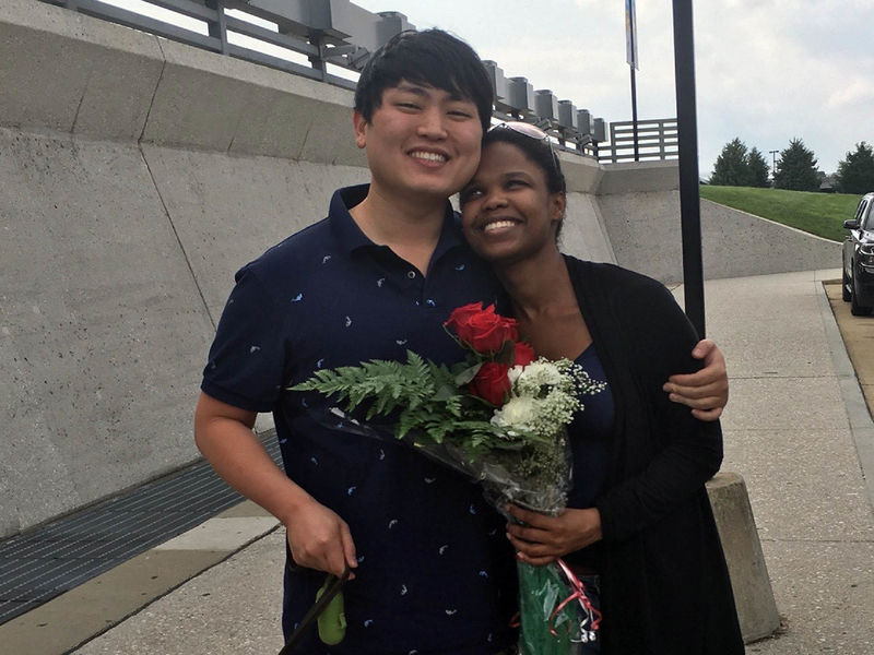 Andy Park hugs his wife, who is holding flowers