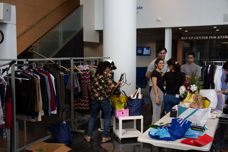 Students looking at clothes and household items in the CCB lobby