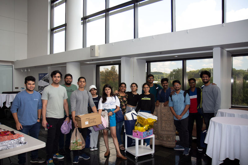 Students holding clothes and household items in the CCB lobby