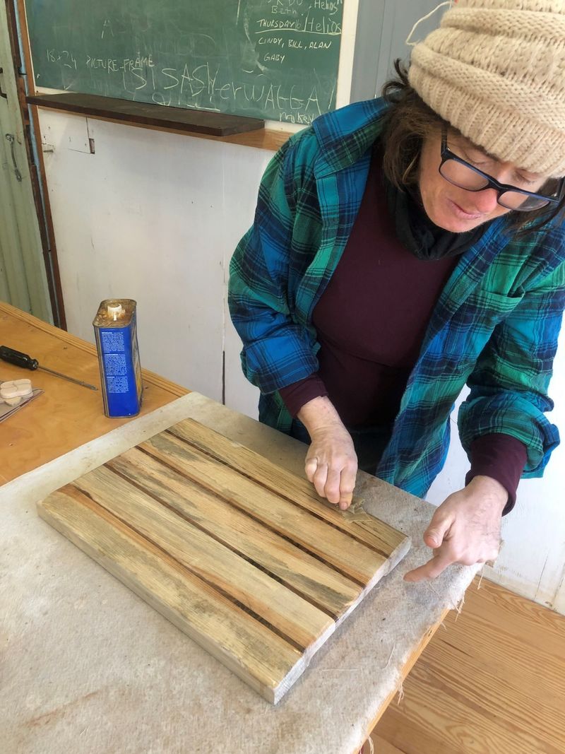 A woman sanding a wooden board