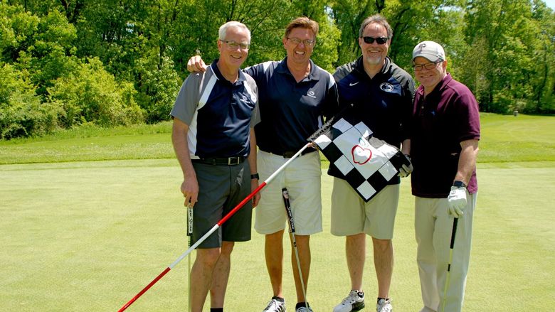 Golfers standing on the putting green at Penn State Great Valley's annual golf outing to support student scholarships
