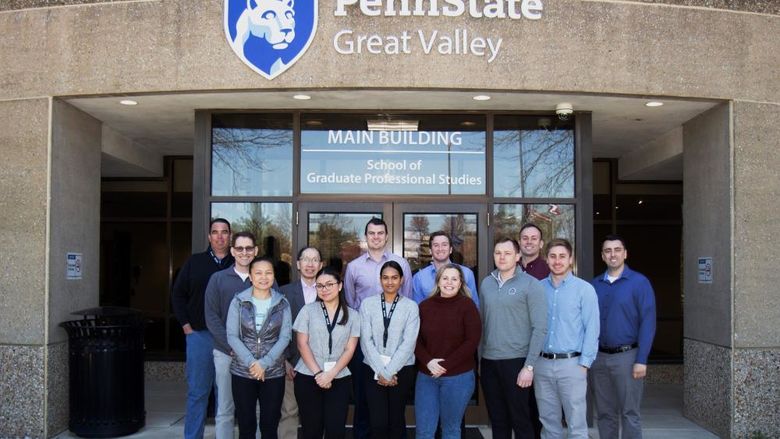 A group of graduate finance students in front of Penn State Great Valley's Main Building