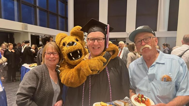 Jason Herman and his parents with the Nittany Lion at Great Valley's commencement ceremony