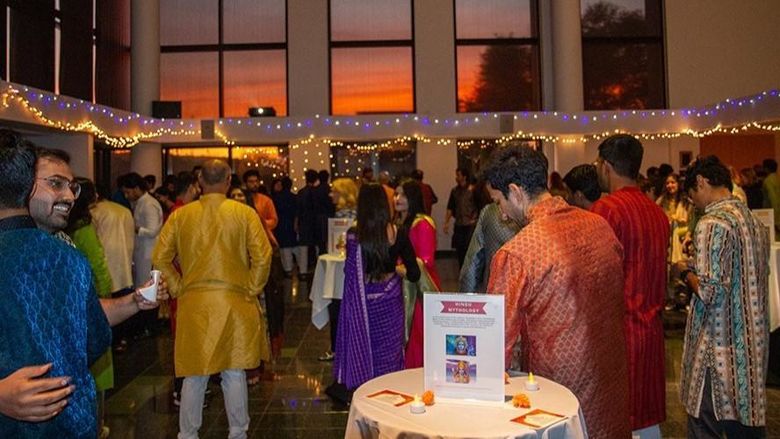 People gather at an event wearing Indian attire