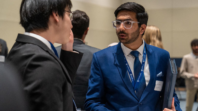 Two young men in suits talking to each other