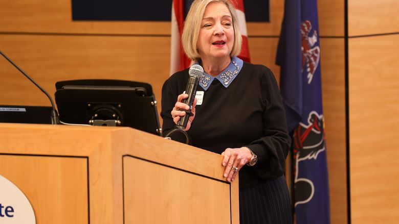 Regional Chancellor Marilyn J. Wells holding microphone