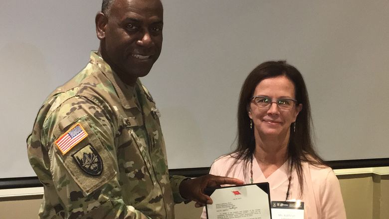 Major General Cedric Wins presenting Kathryn Jablokow with a commendation