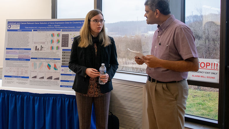 A student discusses her research with a judge
