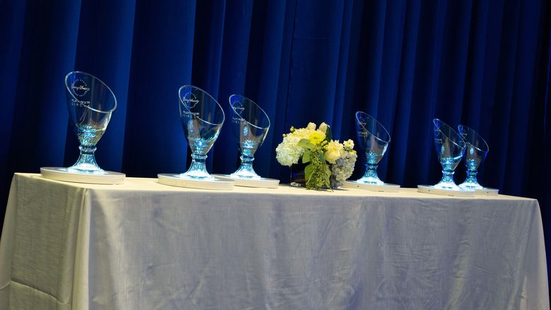 Glass vases etched with the Great Valley Giving Society logo on a table