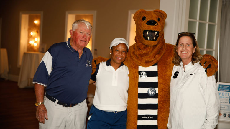 The Nittany Lion mascot poses with three attendees at the Penn State Great Valley golf outing.
