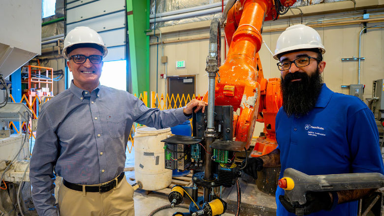 two people standing in machine shop