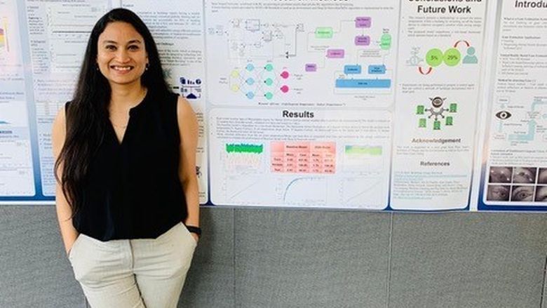 Anchal Gupta in front of her poster presentation
