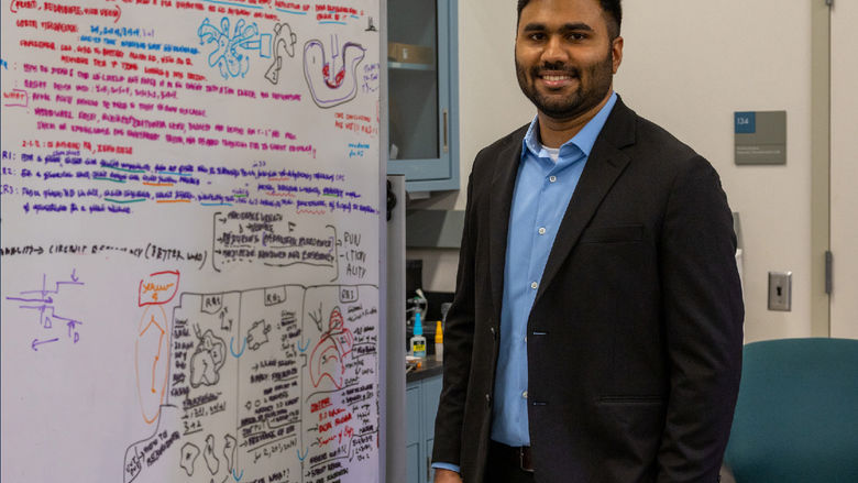 person standing in front of white board with equations