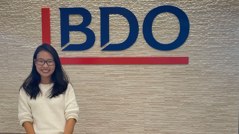 Bolortungalag Mijiddorj standing in front of a wall with the BDO USA logo