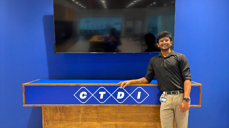 student standing next to TV and CTDI company sign