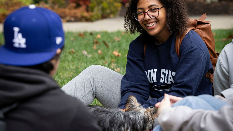 Woman in Penn State sweatshirt talking to other students