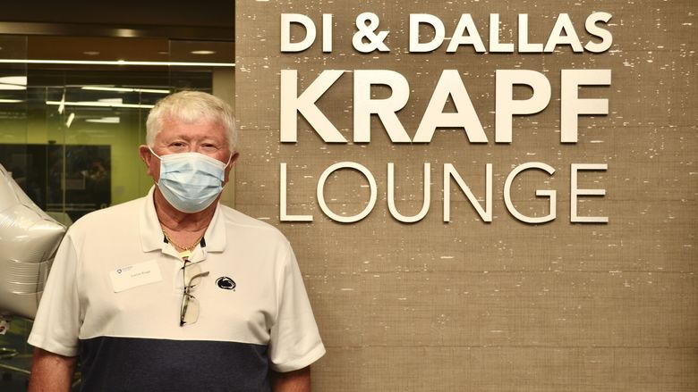 Dallas Krapf standing in front of a wall that says "Di & Dallas Krapf Lounge"