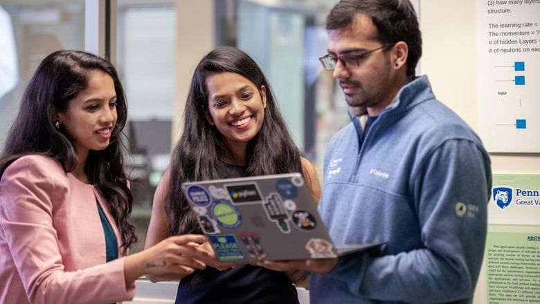 Students looking at a laptop 