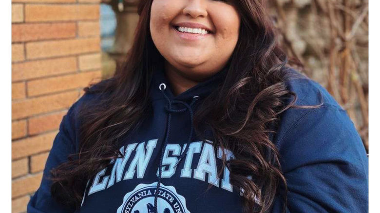 Zeenat Chughtai wearing a Penn State sweatshirt and smiling outside