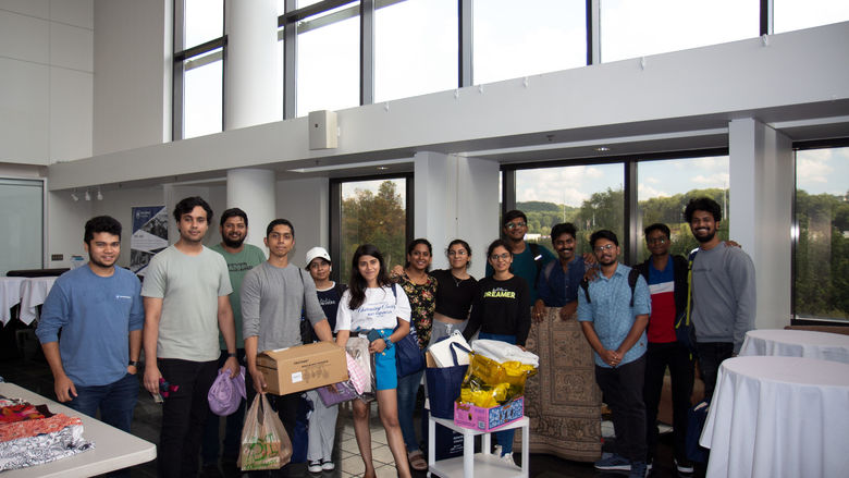Students holding clothes and household items in the CCB lobby