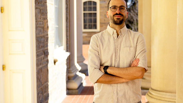 person standing next to Old Main pillars