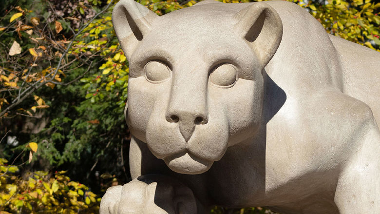 The Nittany Lion Shrine with fall foliage in the background.