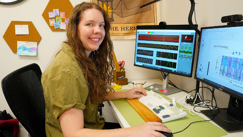 woman sitting at computer smiling at camera