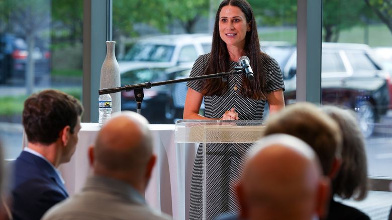 MBA alumna speaks at a podium in front of a group of people