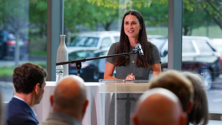 MBA alumna speaks at a podium in front of a group of people